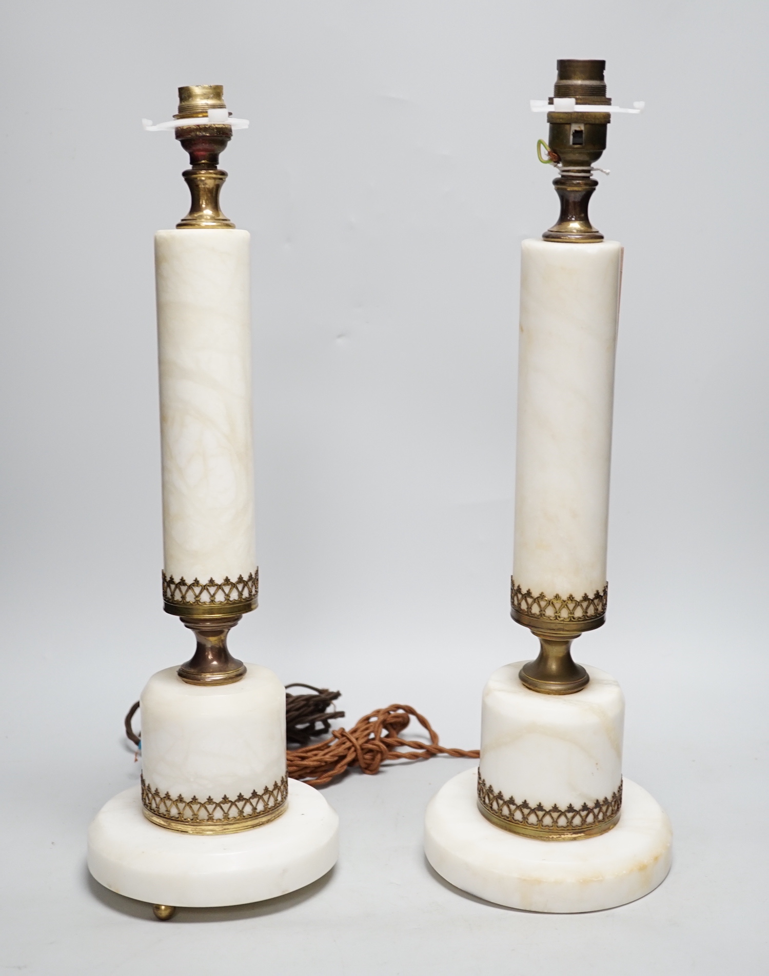 A pair of white marble column table lamps with gilt metal mounts and shades, 61cm high overall